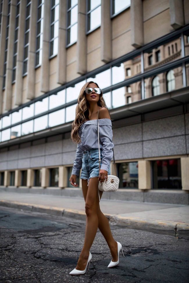 fashion blogger mia mia mine wearing a striped top and denim shorts