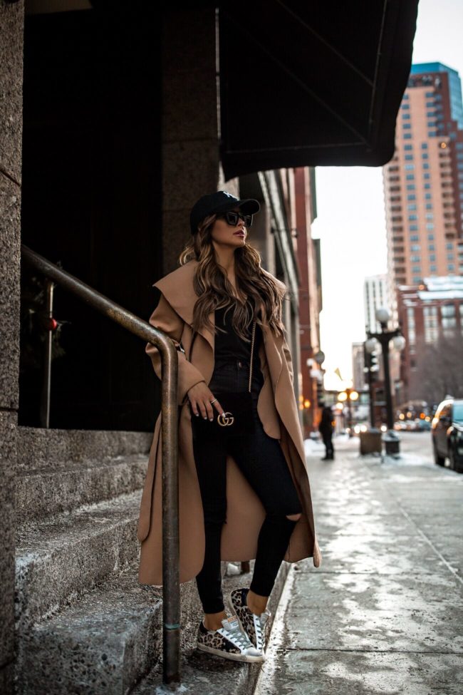 fashion blogger mia mia mine wearing a camel coat and golden goose leopard sneakers from net-a-porter