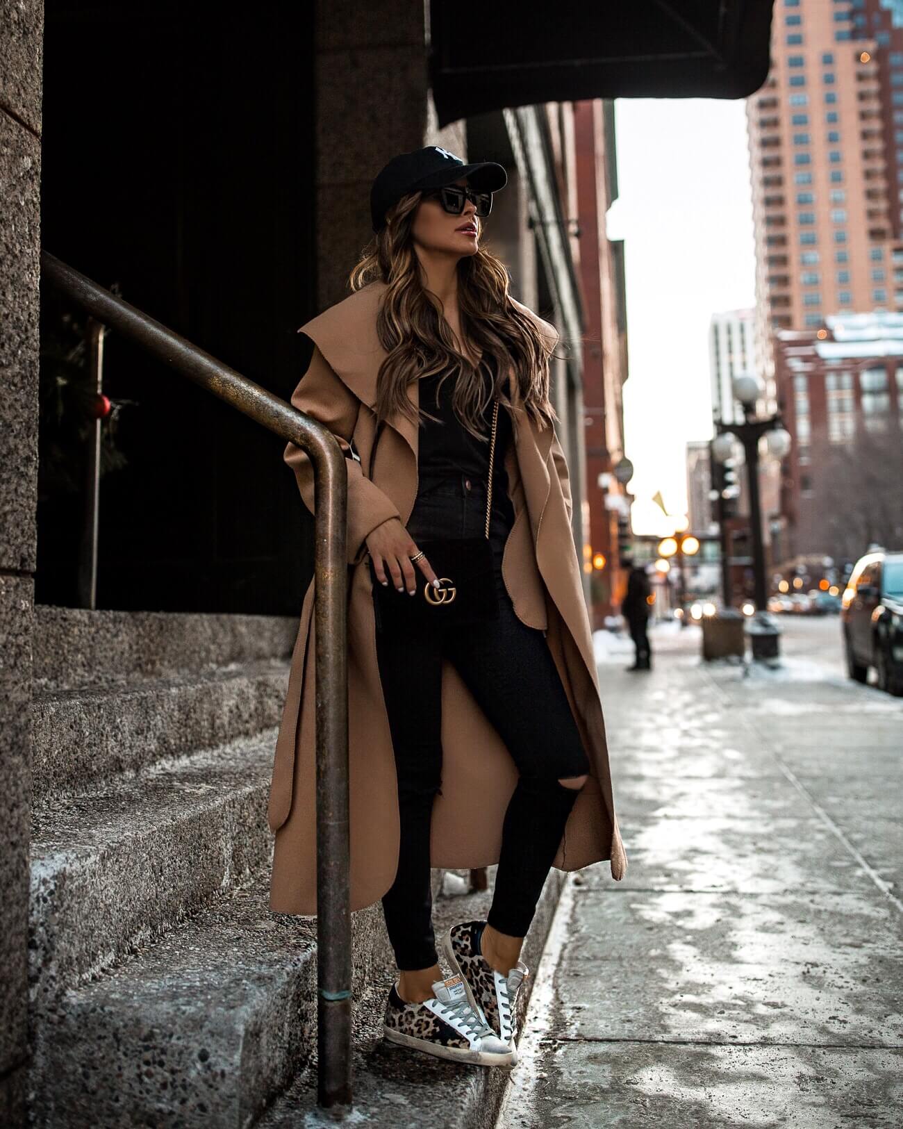 fashion blogger mia mia mine wearing a camel coat and golden goose leopard sneakers from net-a-porter