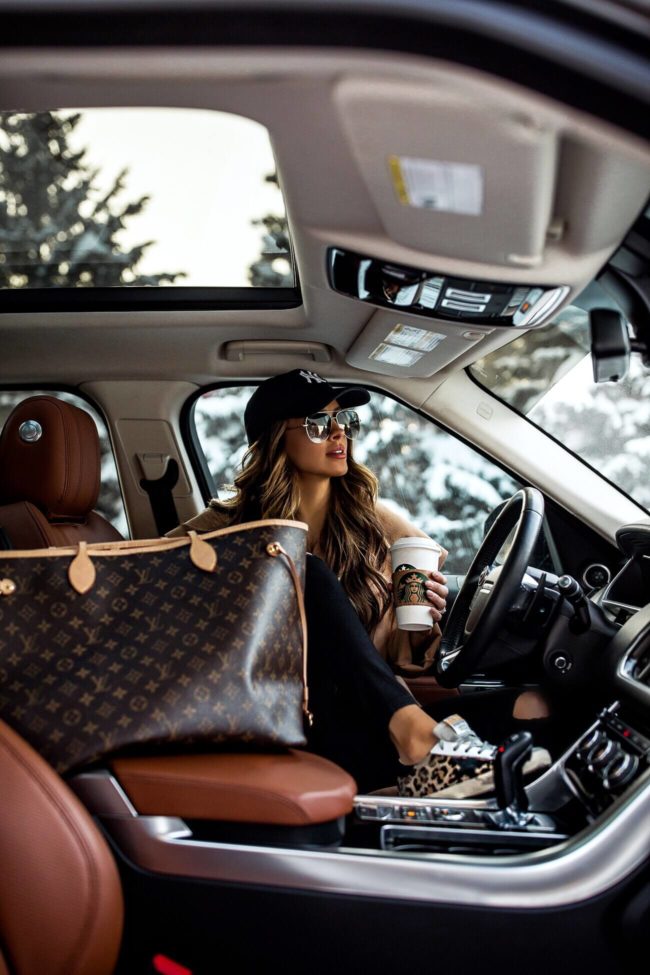 fashion blogger mia mia mine wearing a new york yankees hat and a louis vuitton neverfull bag