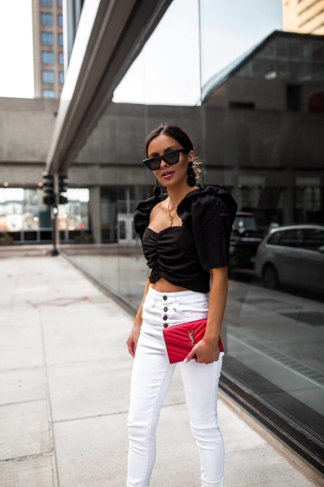 fashion blogger mia mia mine wearing a black crop top and white denim from vici dolls collection