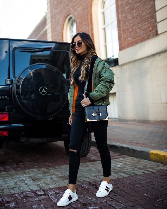 fashion blogger mia mia mine wearing an alpha industries bomber jacket and gucci sneakers