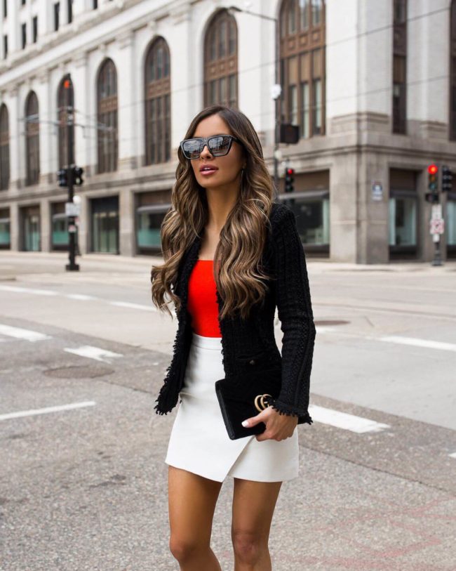 fashion blogger mia mia mine wearing a red crop top and a white leather skirt