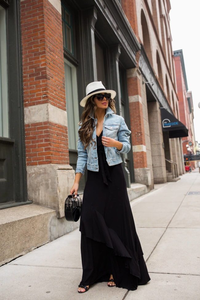 fashion blogger mia mia mine wearing a crop denim jacket and a black maxi dress