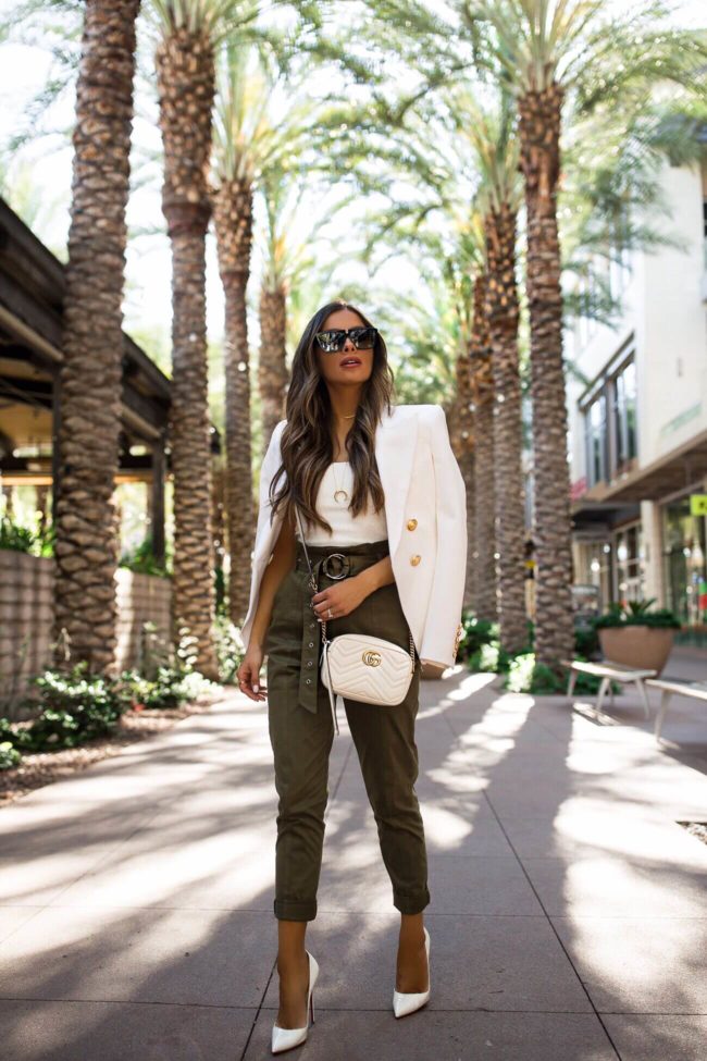 fashion blogger mia mia mine wearing a white blazer and paper bag waist pants from revolve