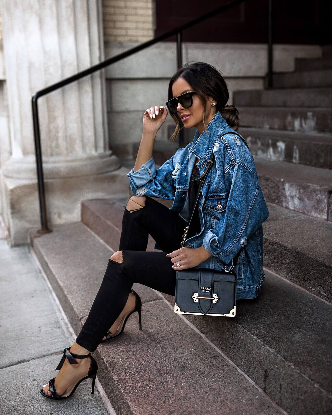fashion blogger mia mia mine wearing a denim jacket and a prada cahier bag