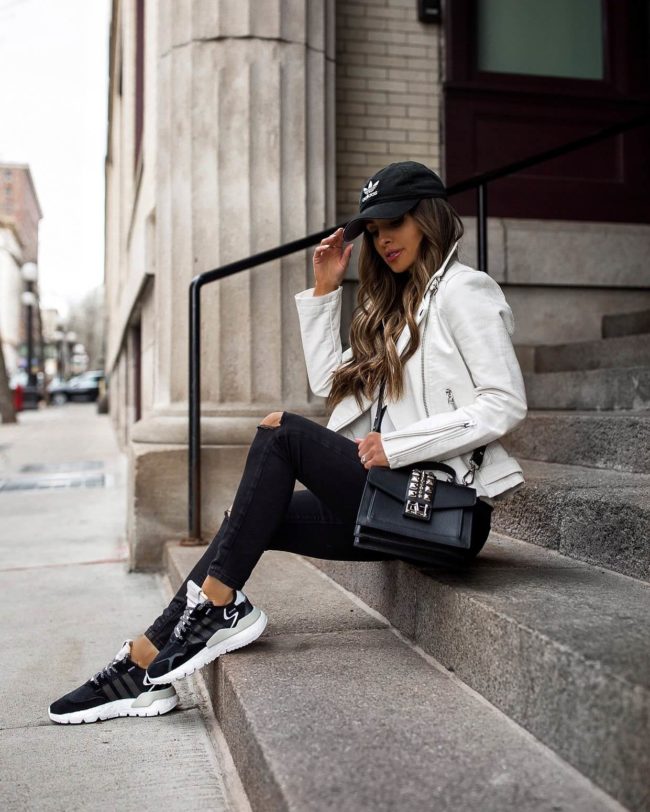 fashion blogger mia mia mine wearing a white leather jacket and adidas sneakers