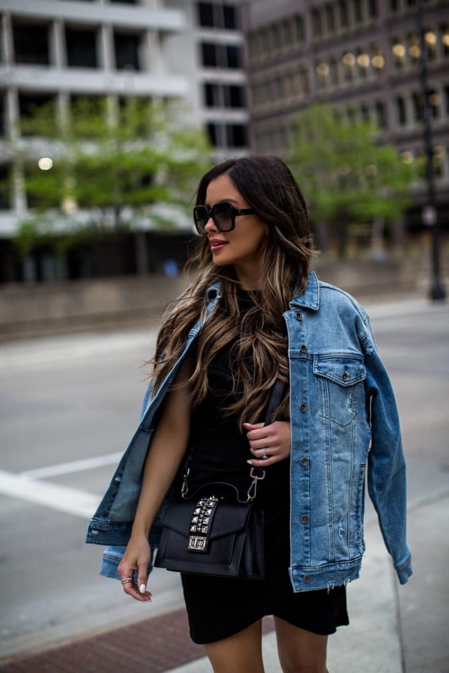 fashion blogger mia mia mine wearing a denim jacket and valentino bag from saks off fifth