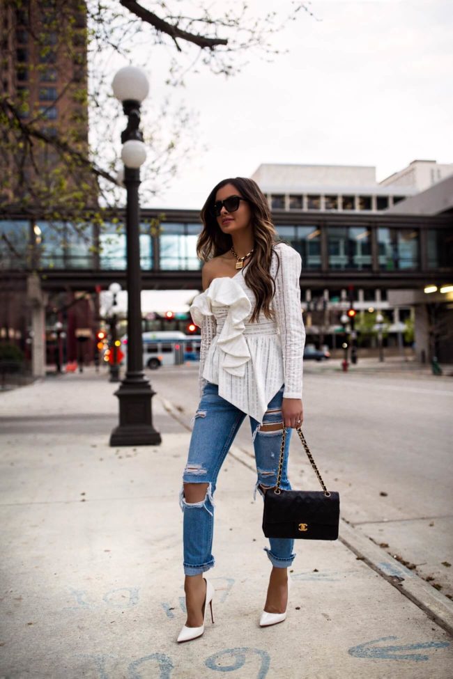 fashion blogger mia mia mine wearing a white off-the-shoulder top and distressed grlfrnd denim