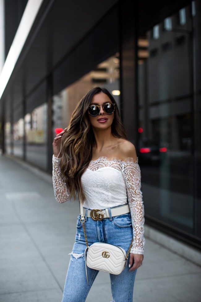 fashion blogger mia mia mine wearing a white lace bodysuit and a white gucci belt