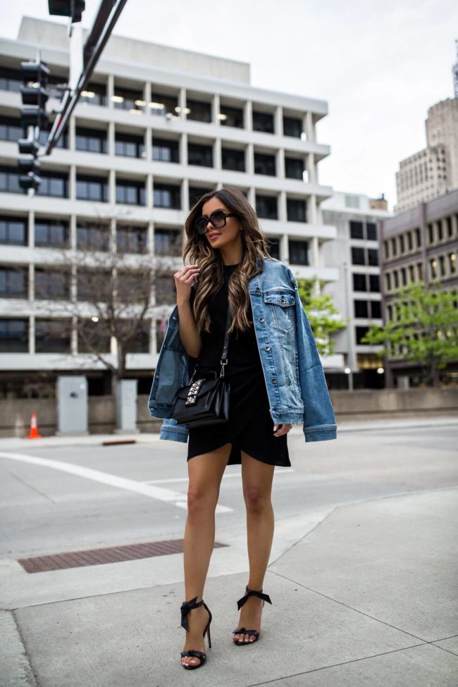 fashion blogger mia mia mine wearing a denim jacket and black knit dress from saks off fifth