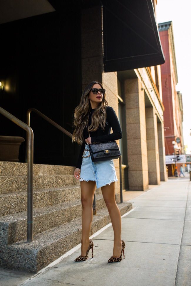 fashion blogger mia mia mine wearing a black bodysuit and a chanel bag from ebay