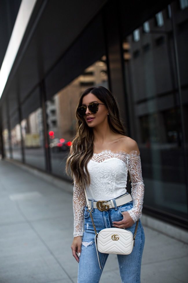 fashion blogger mia mia mine wearing a white lace long sleeve bodysuit from revolve