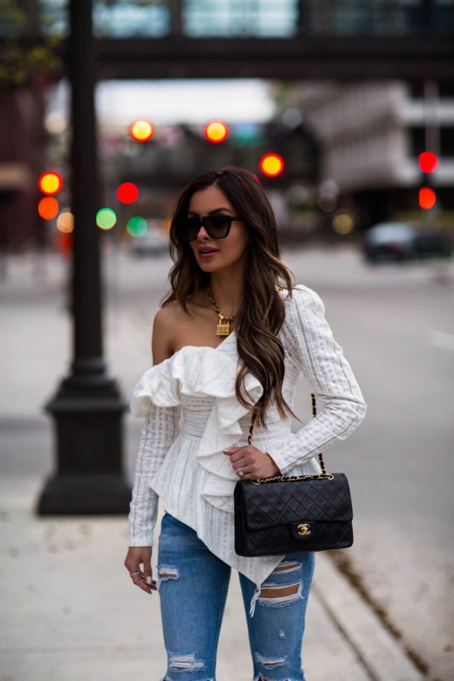 fashion blogger mia mia mine wearing a chanel bag and white off-the-shoulder saks off fifth top