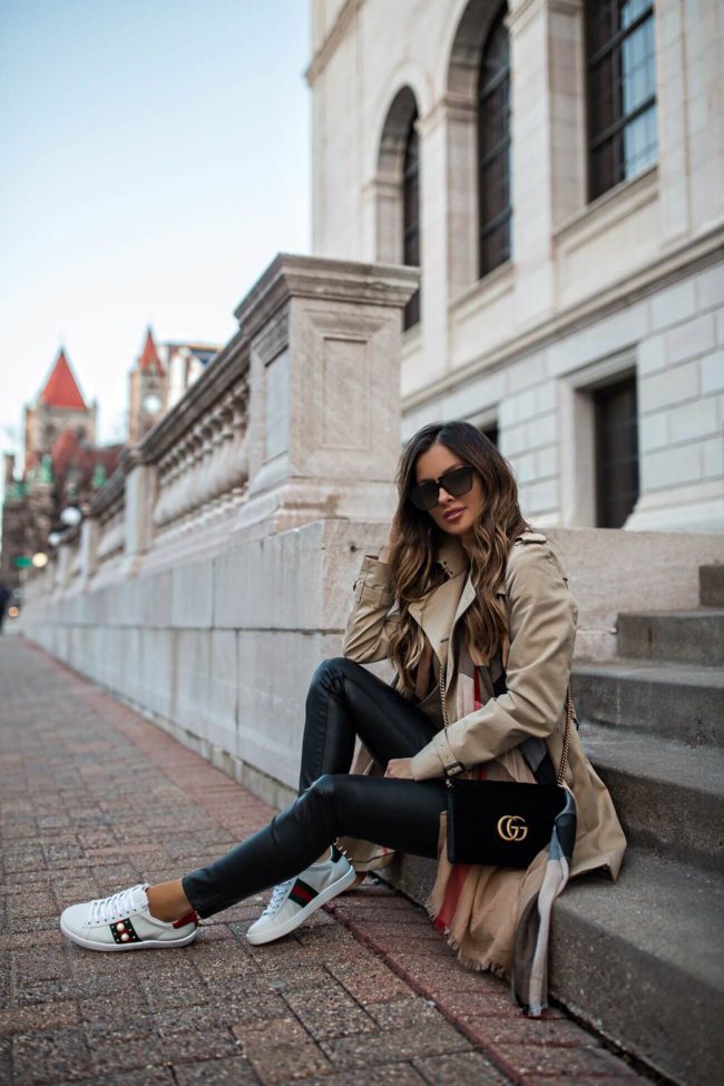 fashion blogger mia mia mine wearing gucci ace embellished sneakers and a burberry jacket