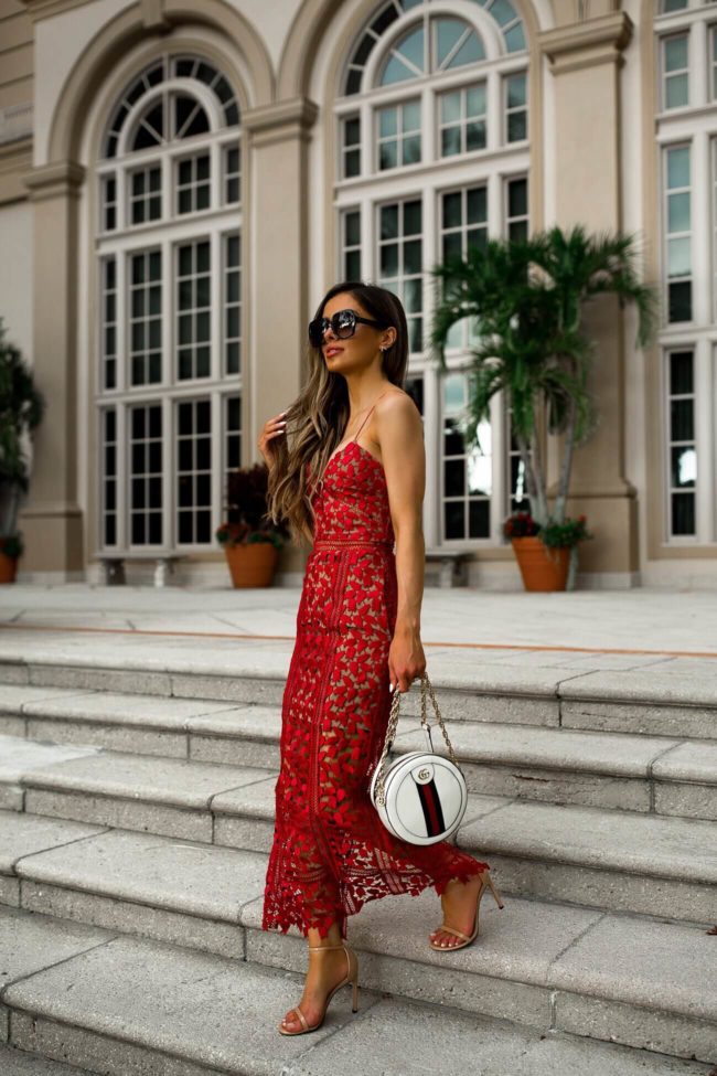Fashion blogger mia mia mine wearing a red lace dress at the ritz-carlton naples