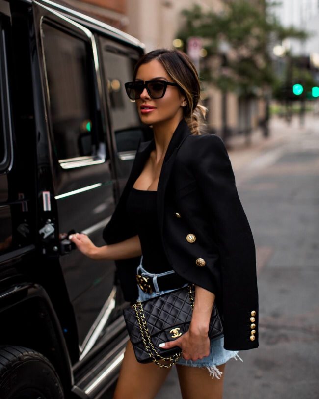 Fashion blogger mia mia mine wearing a balmain blazer and a chanel bag