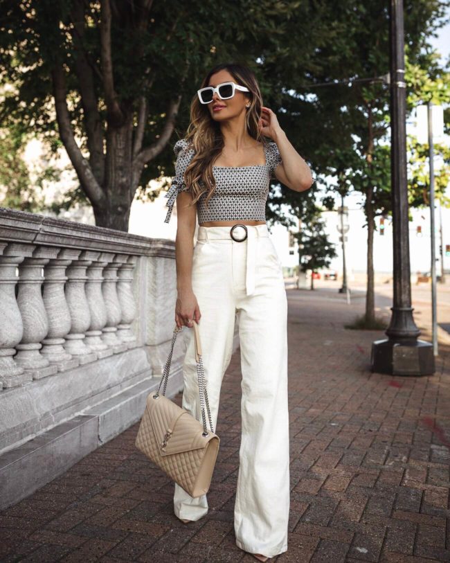 fashion blogger wearing white linen pants and a crop top from revolve for summer 2019