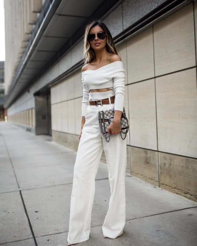 fashion blogger wearing white linen pants from revolve and a white crop top sweater with a gucci dionysus bag
