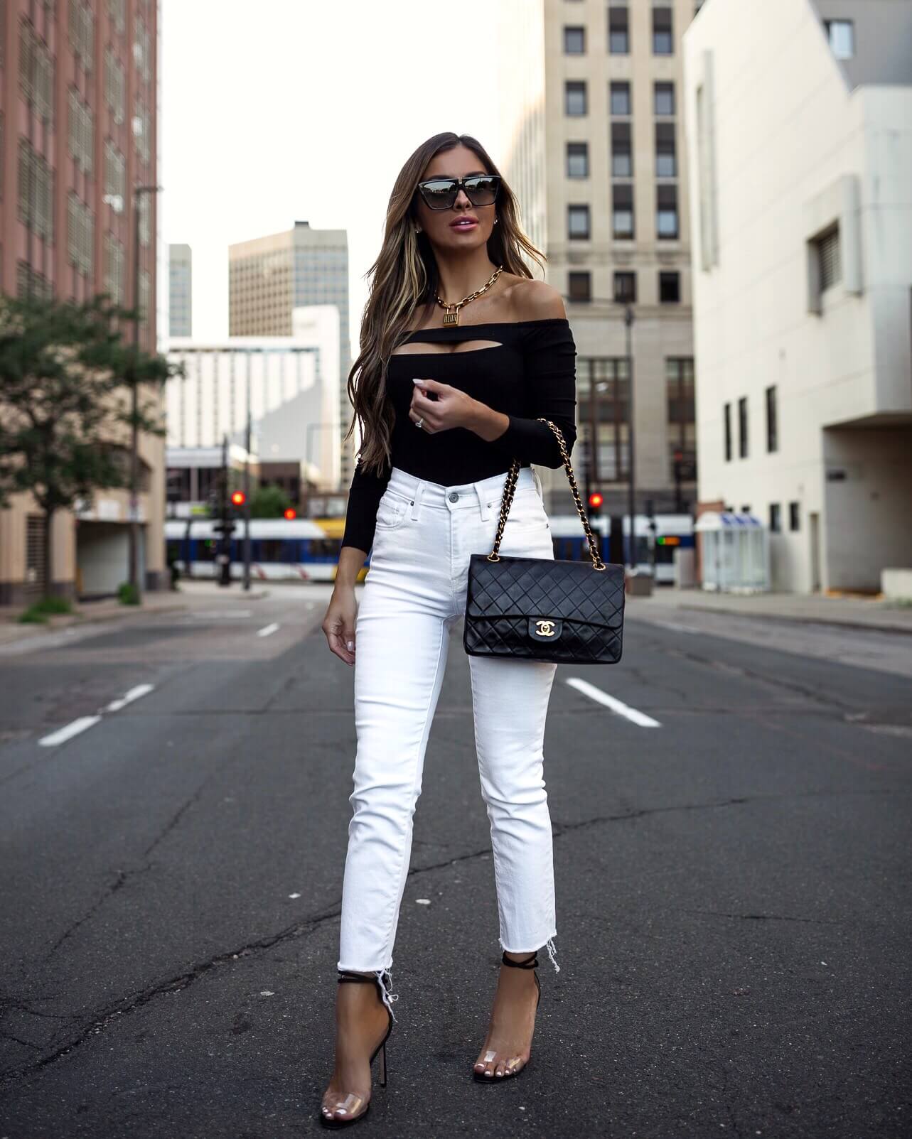 fashion blogger mia mia mine wearing a black bodysuit and white denim with a chanel bag
