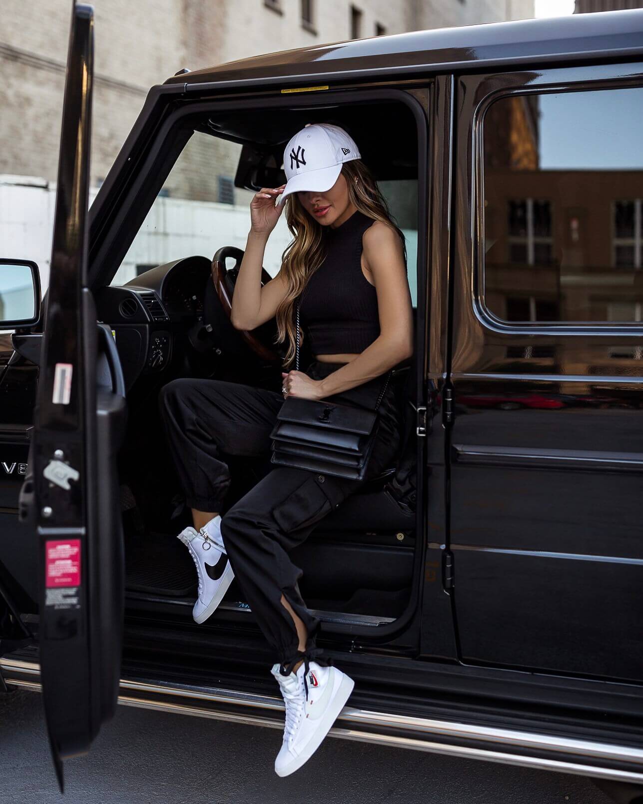 fashion blogger mia mia mine wearing a ny yankees cap and revolve h:ours satin pants with a saint laurent sunset bag