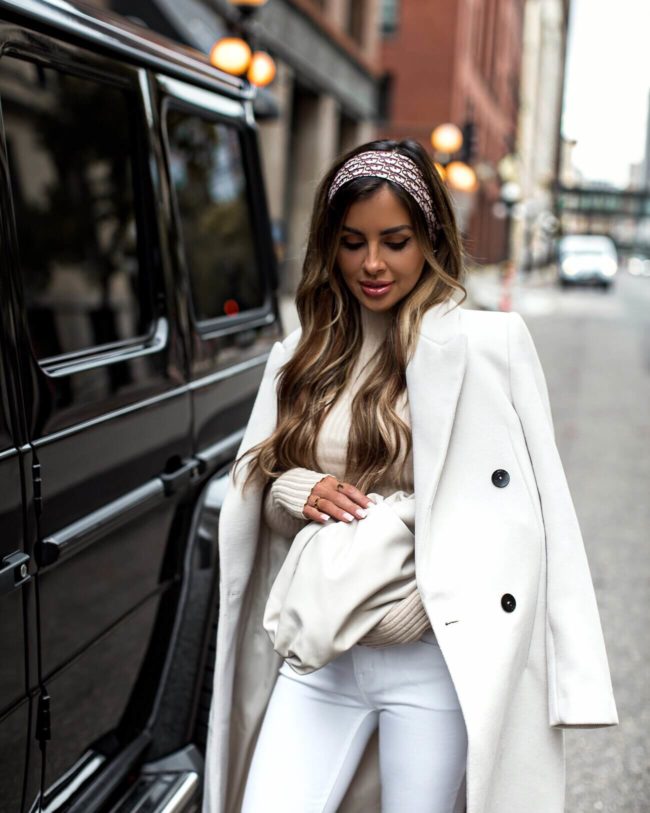 fashion blogger mia mia mine wearing a white outfit with a bottega veneta pouch in mist