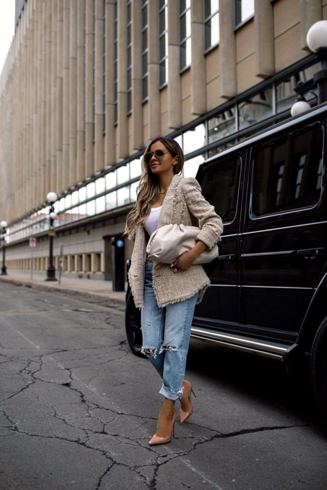 fashion blogger mia mia mine wearing a bottega veneta bag with distressed denim and a balmain blazer