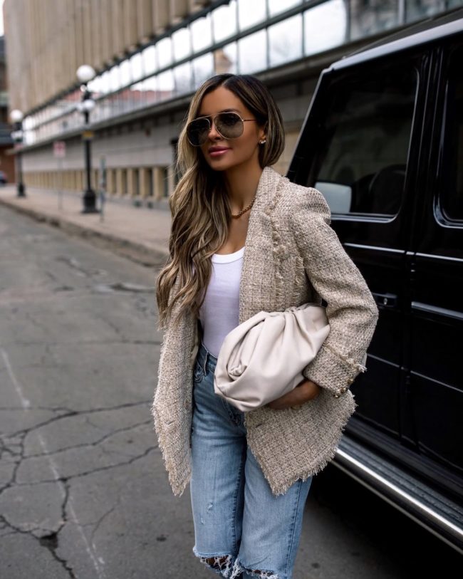 fashion blogger mia mia mine wearing a bottega veneta bag with distressed denim and a balmain blazer
