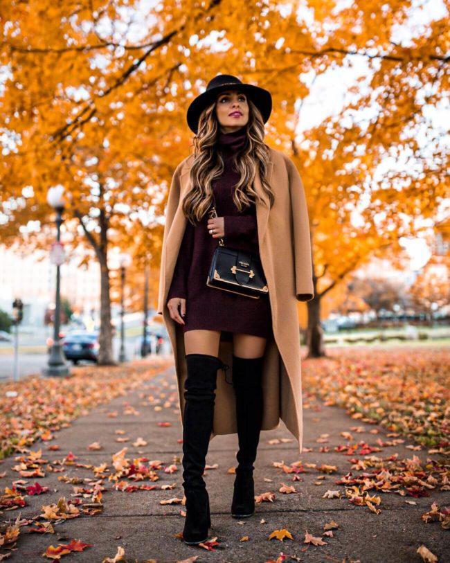 fashion blogger mia mia mine wearing a burgundy sweater dress and black over-the-knee boots by stuart weitzman