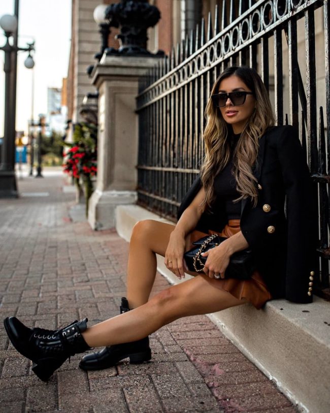 fashion blogger mia mia mine wearing a faux leather skirt and balmain blazer with Chanel combat boots