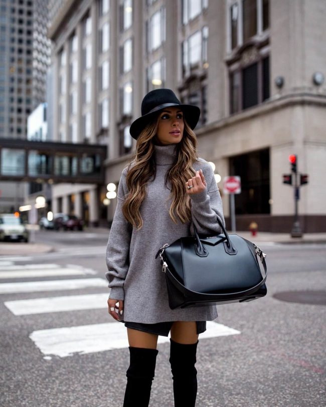 fashion blogger mia mia mine wearing a grey turtleneck tunic with a fedora hat and stuart weitzman highland over-the-knee boots