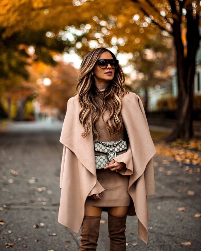 fashion blogger mia mia mine wearing a camel coat and camel sweater dress with brown over-the-knee boots