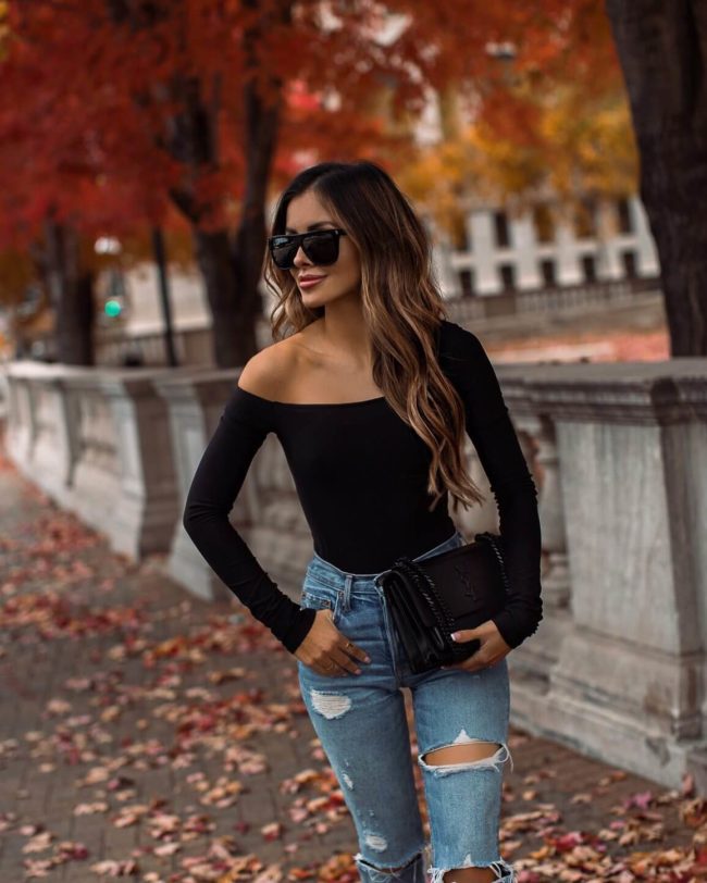 fashion blogger mia mia mine wearing a black one shoulder bodysuit from revolve and grlfrnd denim