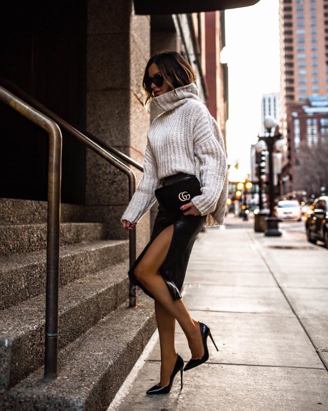 fashion blogger mia mia mine wearing a chunky knit sweater with a faux leather skirt from revolve