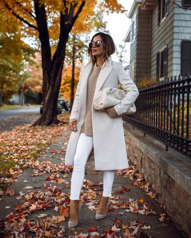 fashion blogger mia mia mine wearing a white coat from mango with a bottega veneta pouch bag in mist