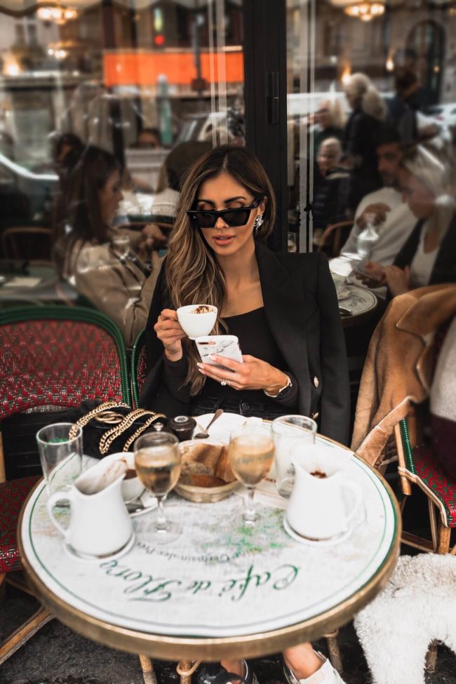 fashion blogger mia mia mine wearing a balmain blazer at a cafe in paris