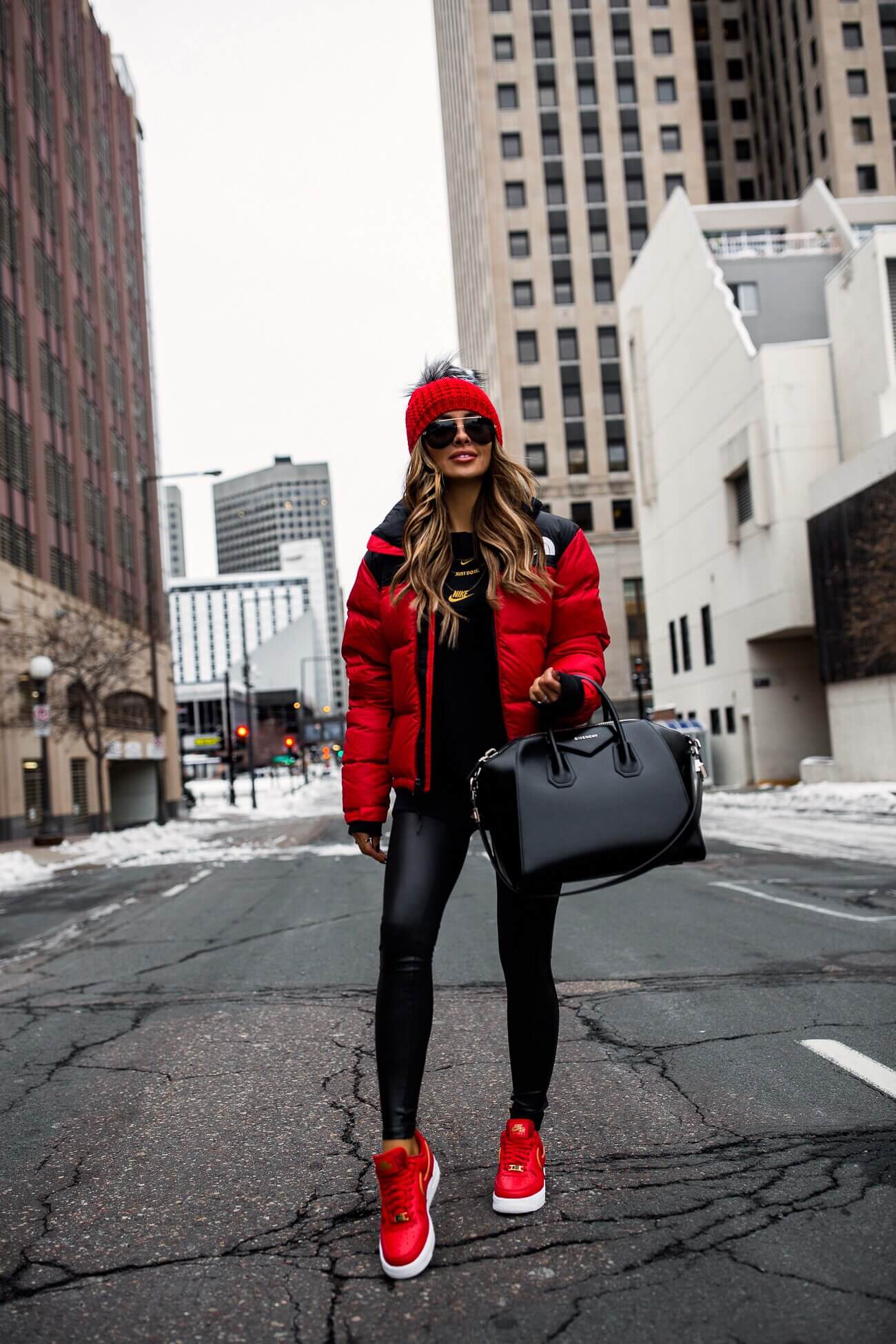 fashion blogger mia mia mine wearing a red puffer jacket and spanx faux leather leggings