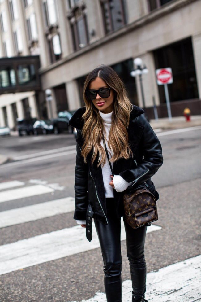 fashion blogger mia mia mine wearing a louis vuitton palm springs mini backpack and a shearling biker jacket