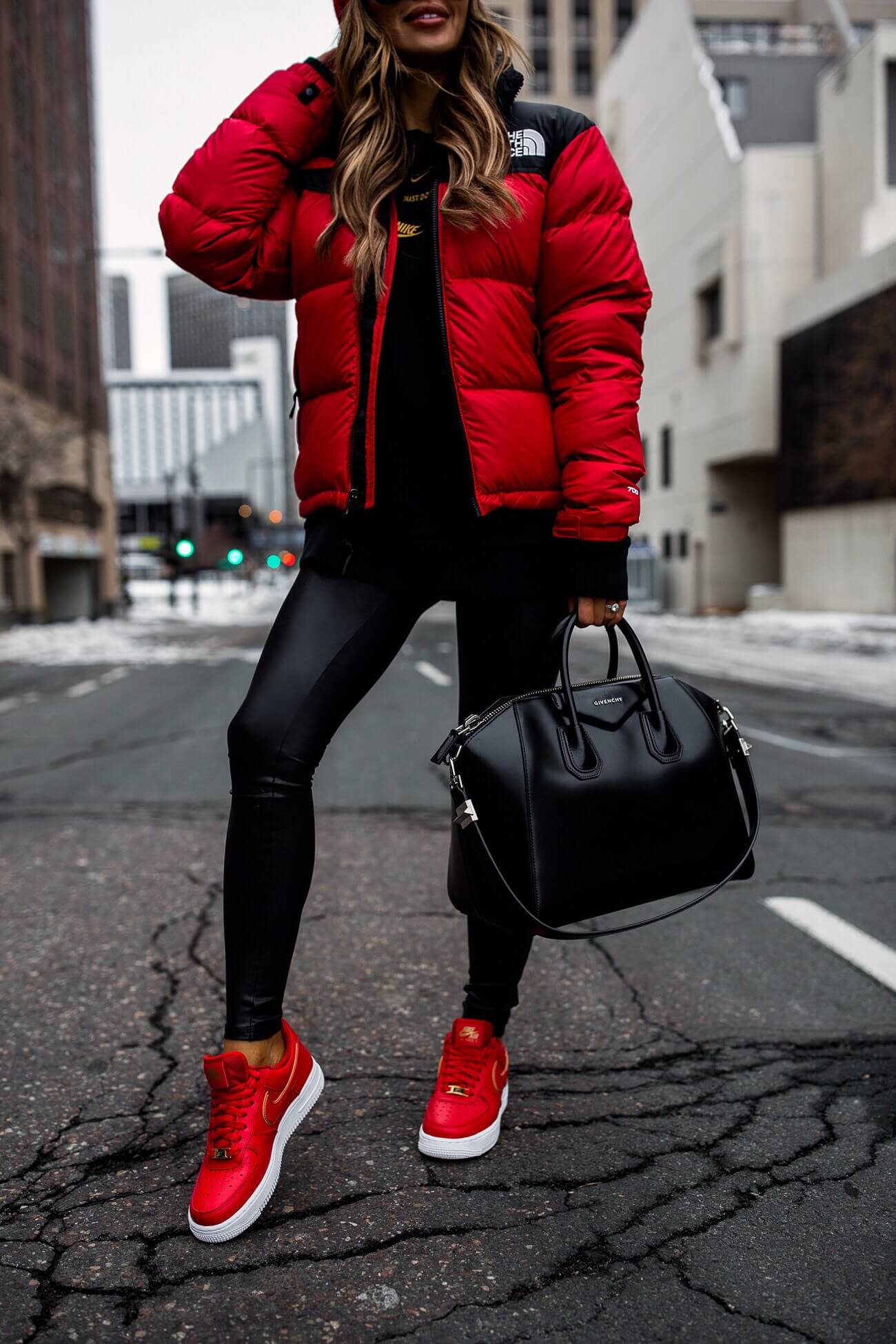 fashion blogger mia mia mine wearing a red north face puffer jacket and red nike air force 1's