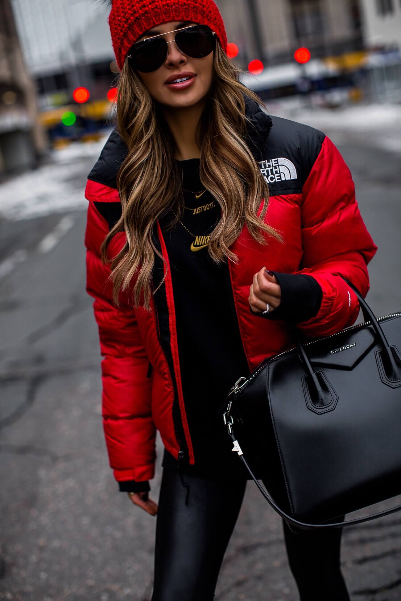 mia mia mine wearing a red north face jacket and a givenchy antigona bag