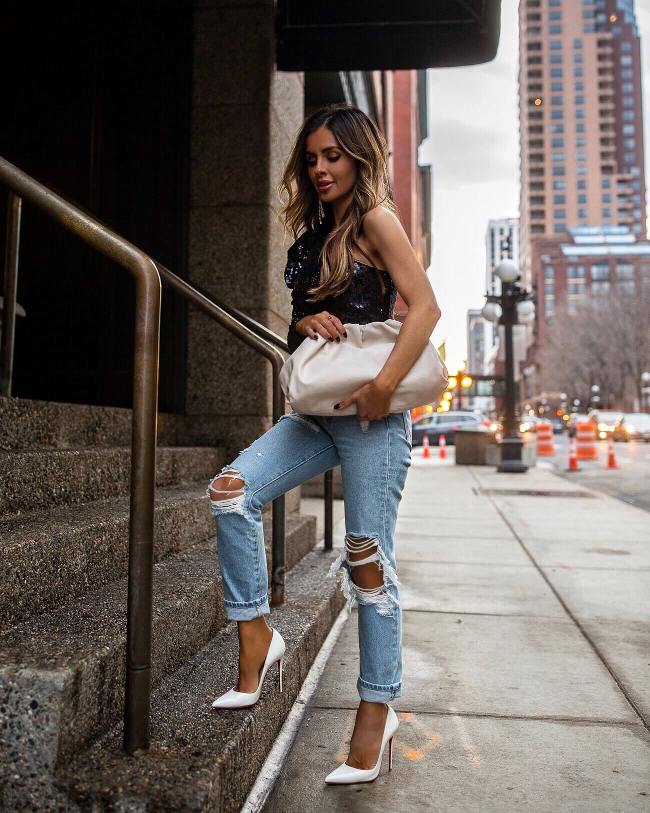 fashion blogger mia mia mine wearing a sequin one shoulder top from revolve with grlfrnd denim