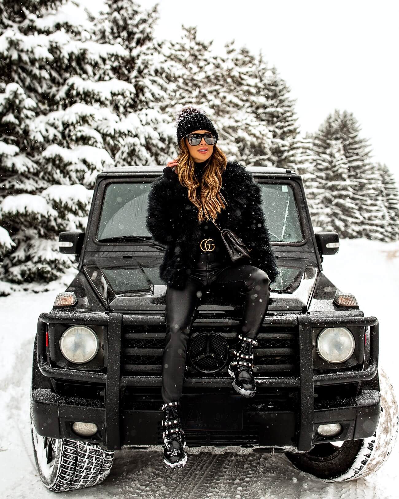 fashion blogger mia mia mine wearing a feather jacket and a gucci belt in winter 2019
