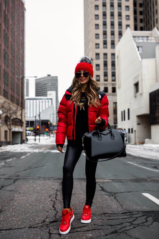 fashion blogger mia mia mine wearing a red north face jacket with spanx faux leather leggings