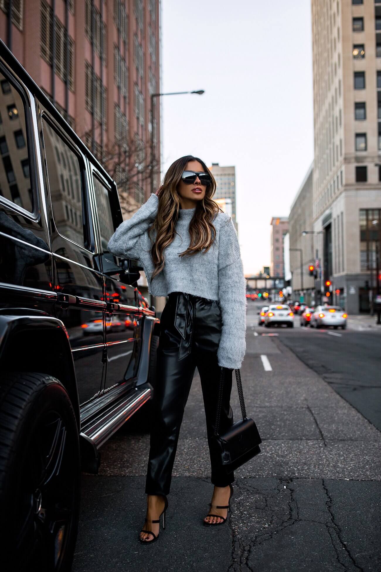 fashion blogger mia mia mine wearing a gray chunky sweater and faux leather pants from express