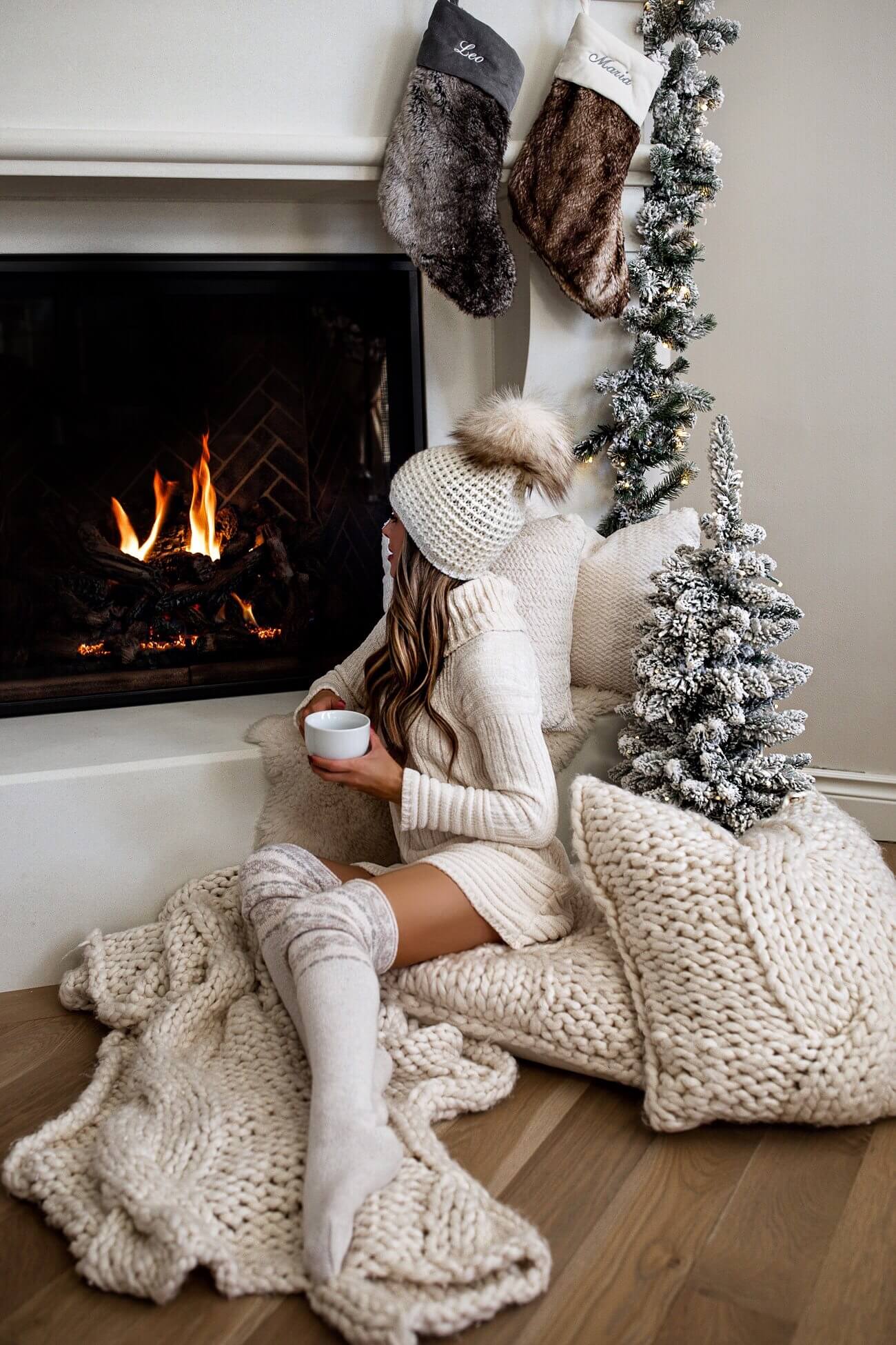 fashion blogger mia mia mine wearing a white bcbgeneration sweater at home by fireplace
