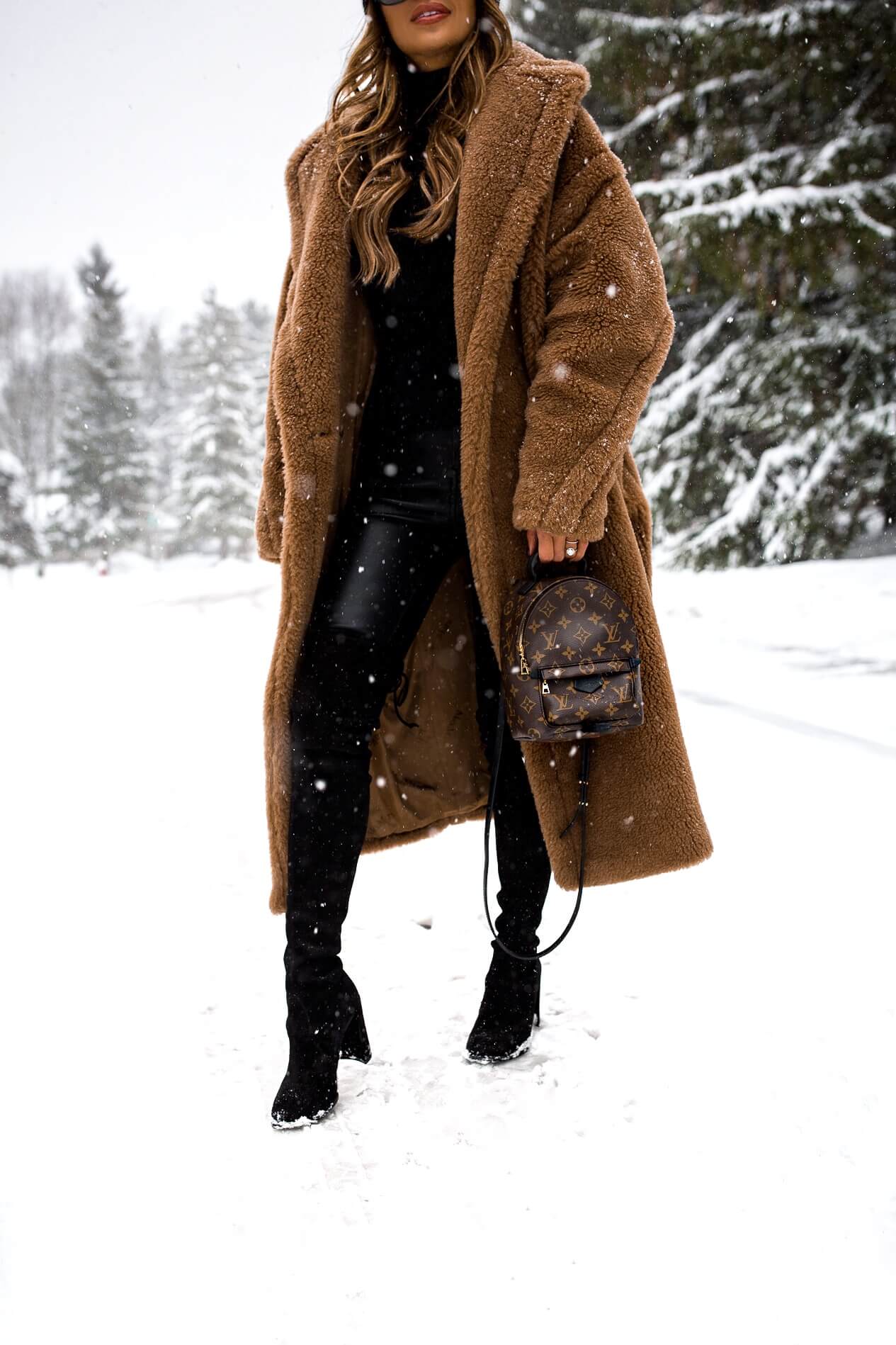 fashion blogger wearing stuart weitzman over-the-knee boots and a louis vuitton palm springs mini backpack
