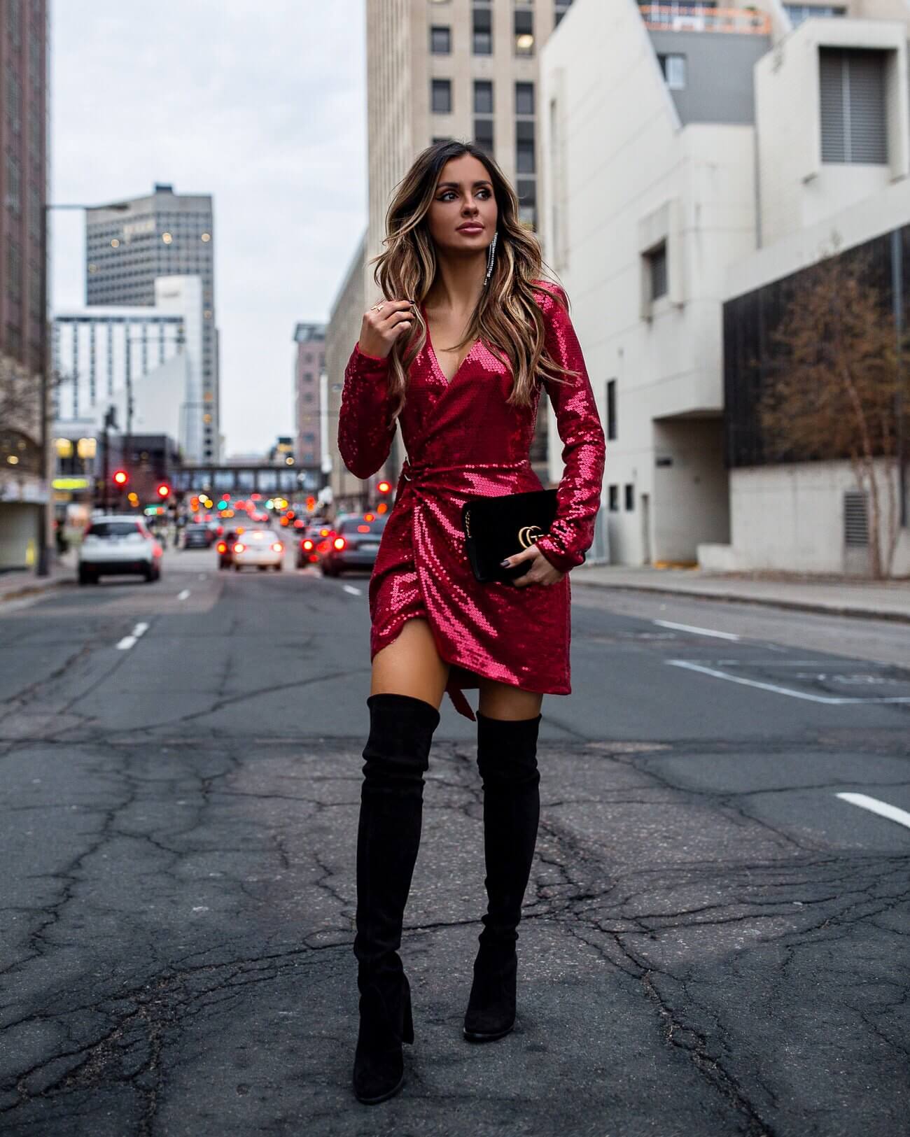 fashion blogger mia mia mine wearing a red sequin dress and over-the-knee stuart weitzman over-the-knee boots