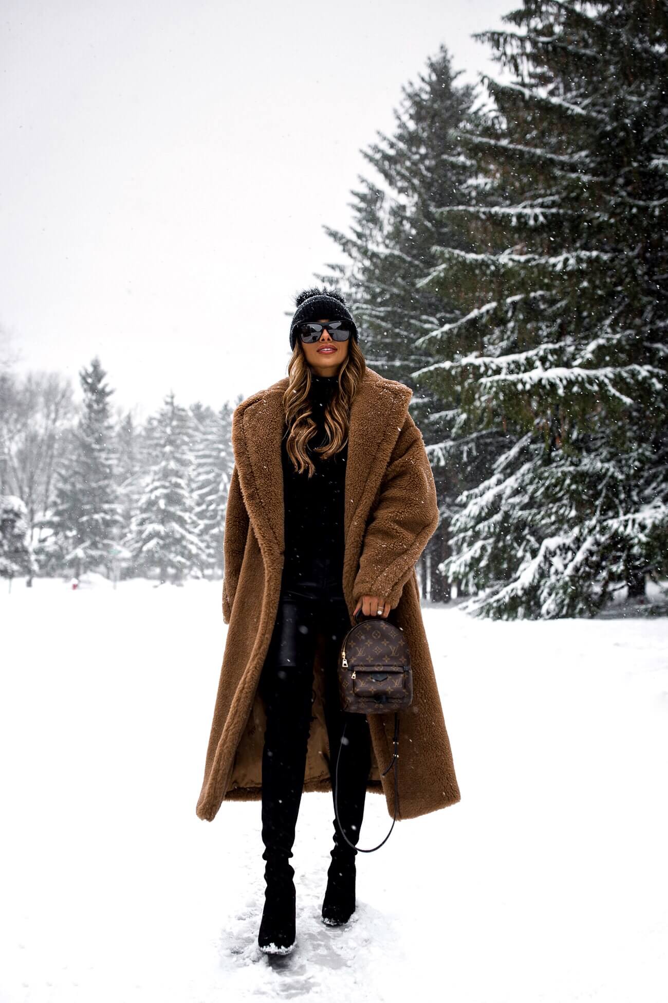 fashion blogger mia mia mine wearing a camel coat from max mara and a louis vuitton palm springs mini backpack
