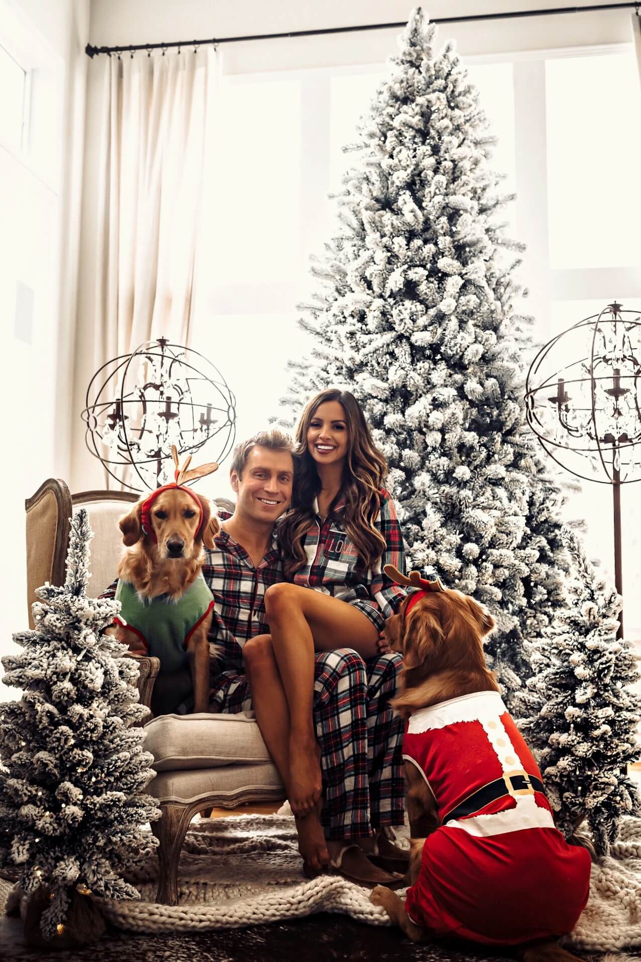 fashion blogger mia mia mine wearing a plaid christmas romper pj set with husband and dogs