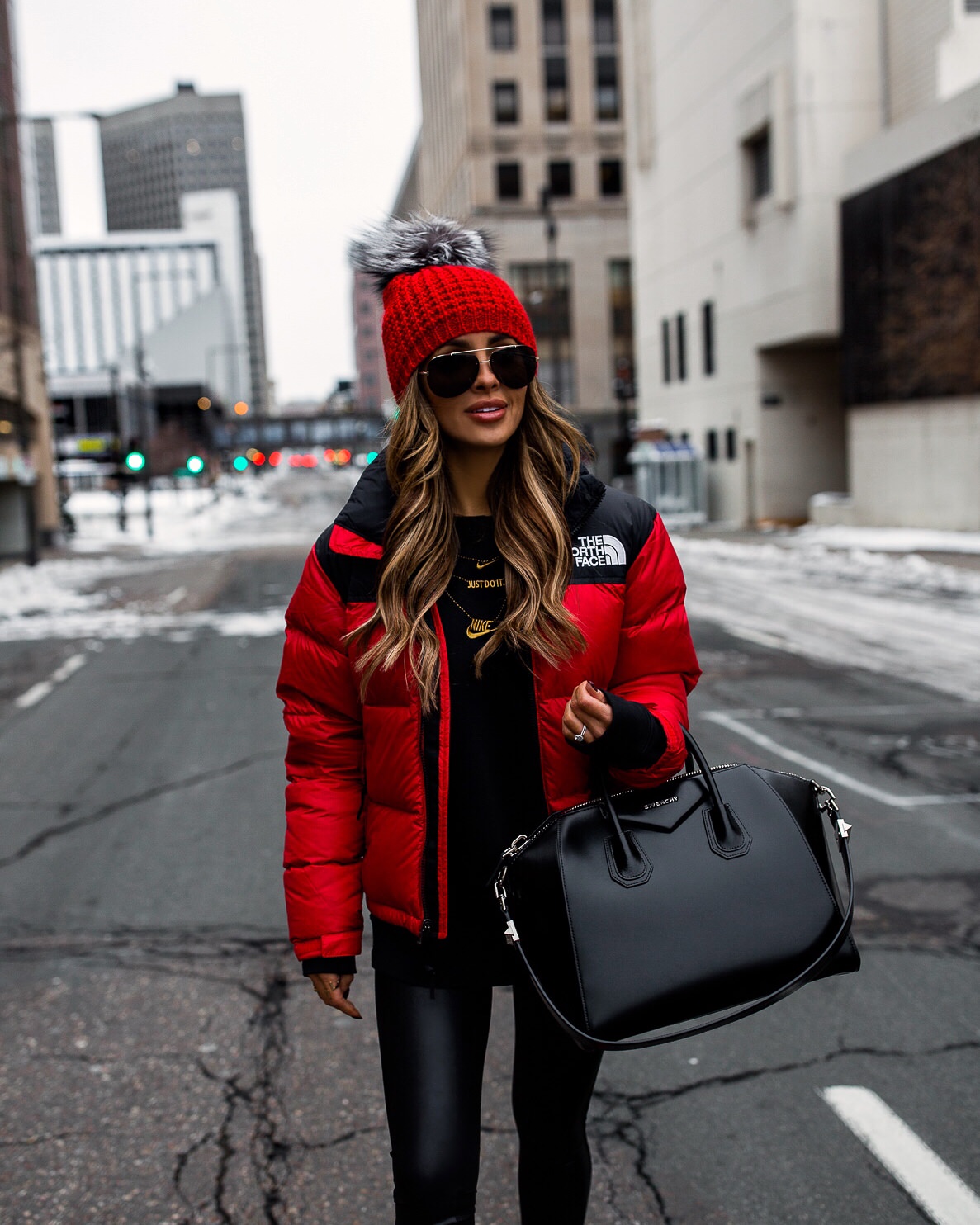fashion blogger mia mia mine wearing a red north face jacket with a givenchy antigona bag